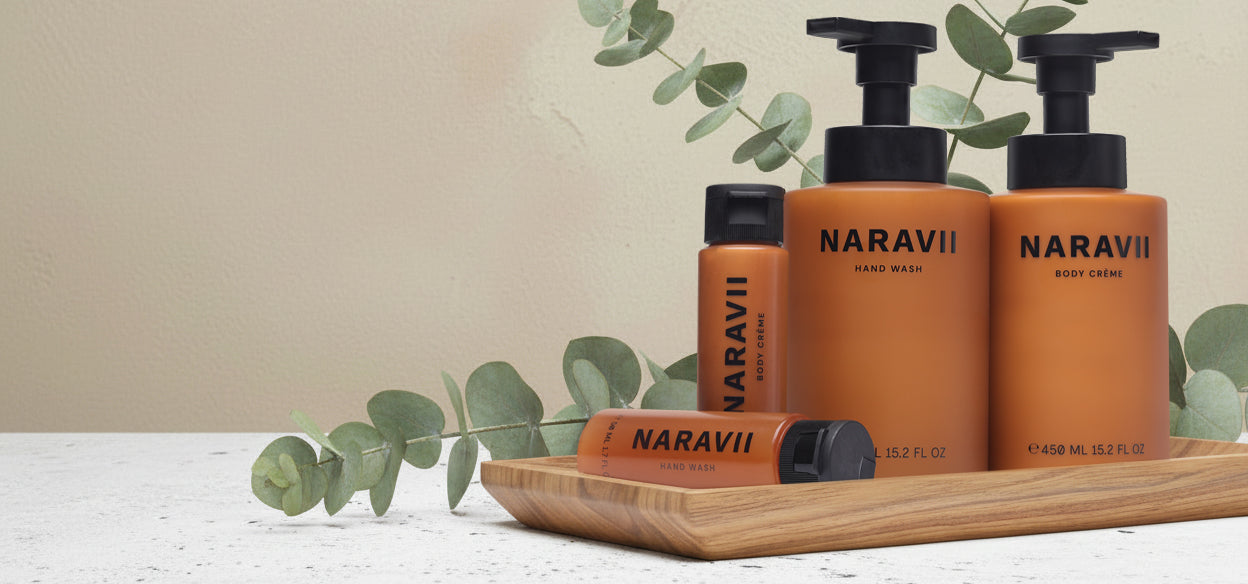 Naravii skincare products on a wooden tray with eucalyptus leaves against a beige background